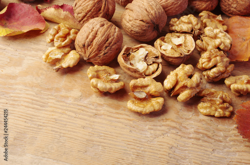 Walnut kernels, broken and whole nuts on a wooden table. 