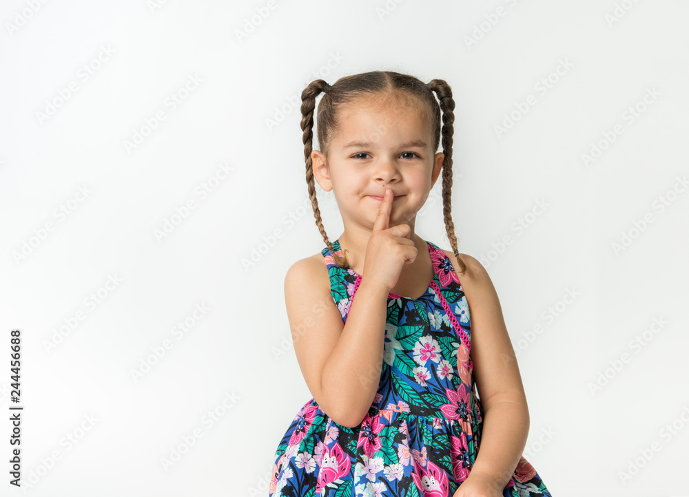 Mixed race little girl gestures for quiet with finger to lips Mixed race little girl gestures for quiet with finger to lips