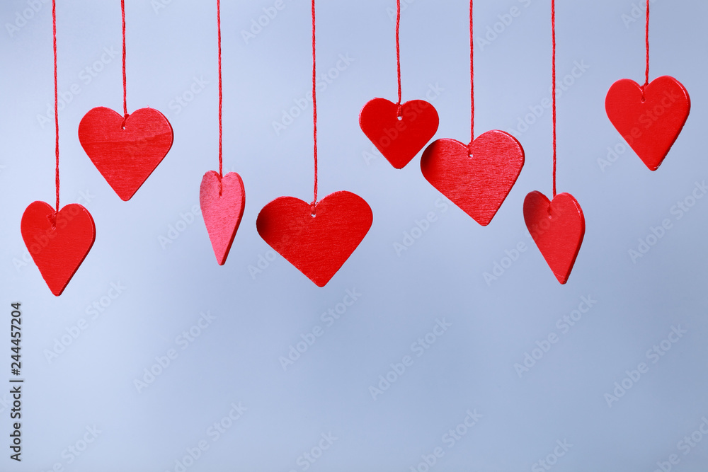 Red hearts hanging against blank background Red hearts hanging against blank background