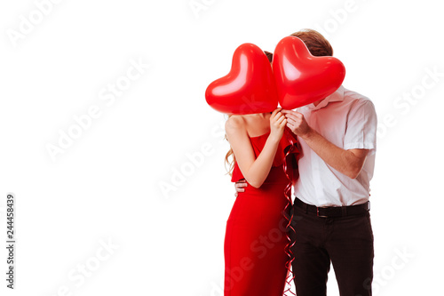 Kissing couple posing on white background with balloons heart. Valentine's day.
