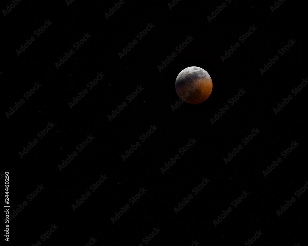 Blood Wolf Moon 2019 in night sky; orange and red moon in night sky with stars Blood Wolf Moon 2019 in night sky; orange and red moon in night sky with stars