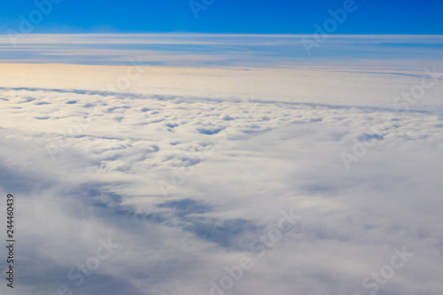 Beautiful white clouds in blue sky. View from airplane