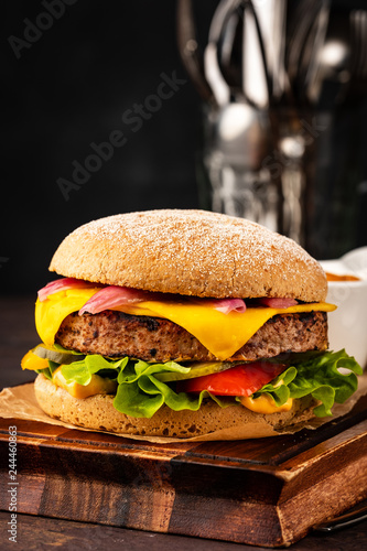 Delicious fresh homemade cheeseburger with marinated onions and red pepper. Beef Burger with Cheese and Vegetables.