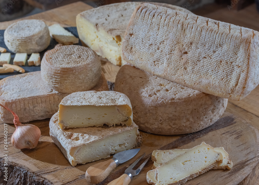 Various sliced cheese on wooden background