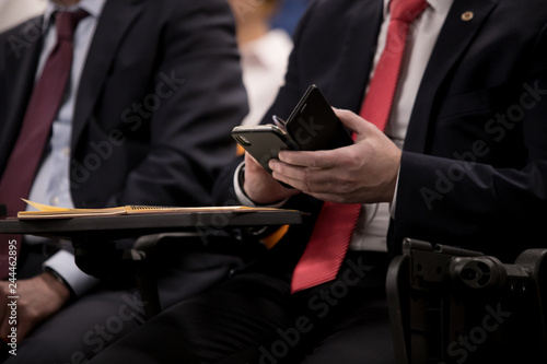 Close-up of businesspeople hands holding pens and papers near table at business seminar