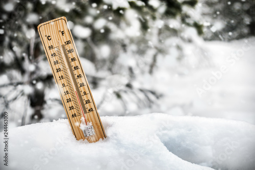 Photography thermometer with sub-zero temperatures sticking out of the snow
