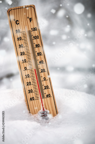 thermometer with subzero temperature stuck in the snow in the winter forest