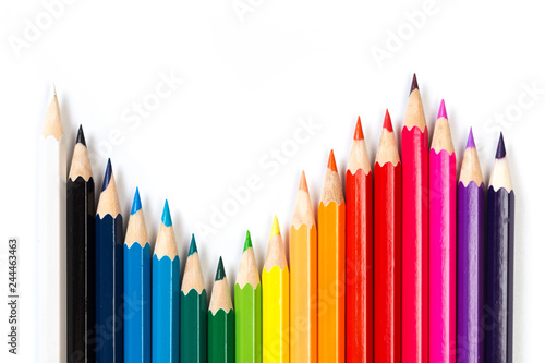 Colour pencils on white background, top view.