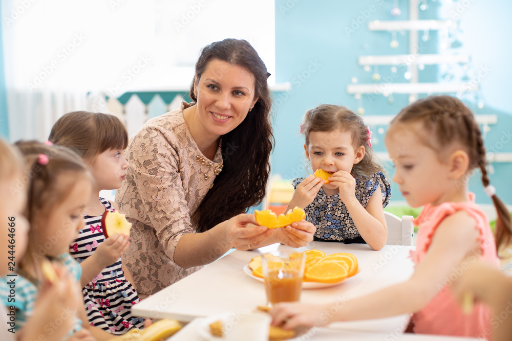 Foto de Children and carer together eat fruit as a snack in the