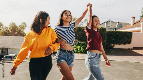 Happy teenage girls walking on street