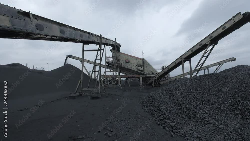 A special coal distributing machine is dropping chunks of coal into the big pile A special coal distributing machine is dropping chunks of coal into the big pile