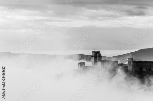 A view of Rocca Maggiore castle in Assisi  Umbria  Italy  in the middle of fog
