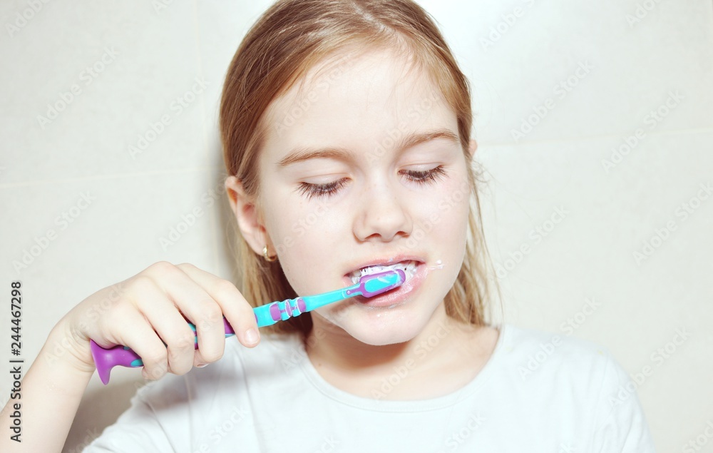 Close up of a child (kid) white European Caucasian girl washing the teeth with toothbrush Close up of a child (kid) white European Caucasian girl washing the teeth with toothbrush