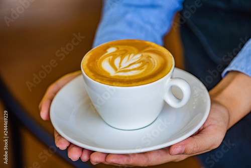 Hands holding coffee cup flower on coffee cup and woman finger.