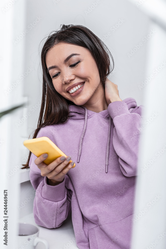 Beaming appealing woman feeling happy receiving message from boyfriend Beaming appealing woman feeling happy receiving message from boyfriend