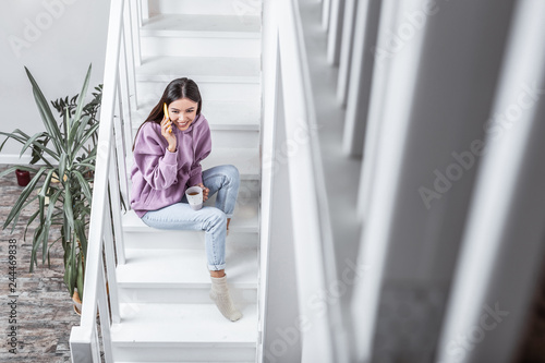 Free Download Young woman chilling while drinking tea and speaking on the phone - GFXLoad