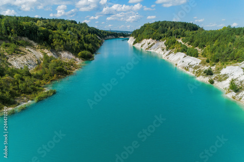 Abandoned mountain quarry. The mine workings are filled with water of a deep blue color. Aerial view © nordroden