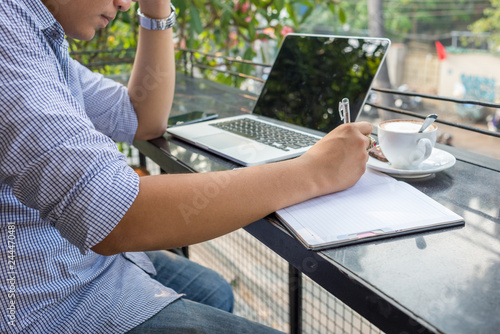 Young man writing notes outdoor the office