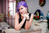 I'm bored in the new year - Concept portrait of a beautiful girl with purple hair in a room sitting on a sofa and bored.