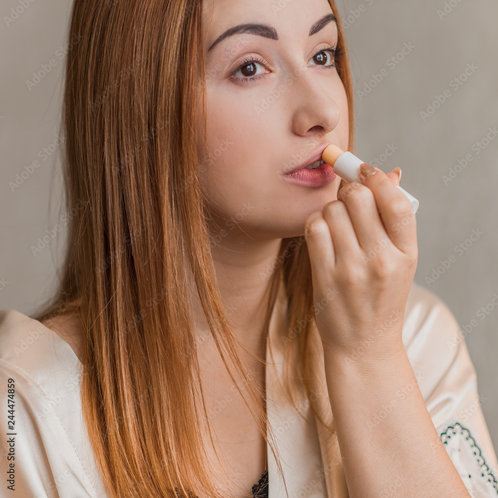 Lips care. Woman applying balsam on lips Lips care. Woman applying balsam on lips