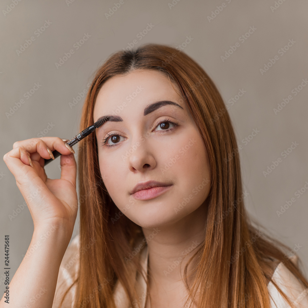 Brow Care. Closeup Of Beautiful Female Model Applying Brow Gel For Eyebrows. Portrait Young Woman. Beauty cosmetics Concept. 