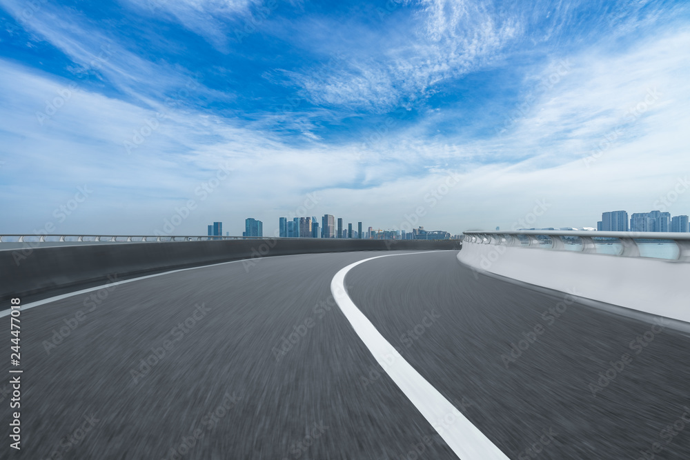 Fototapeta premium road through the bridge with city skyline background.