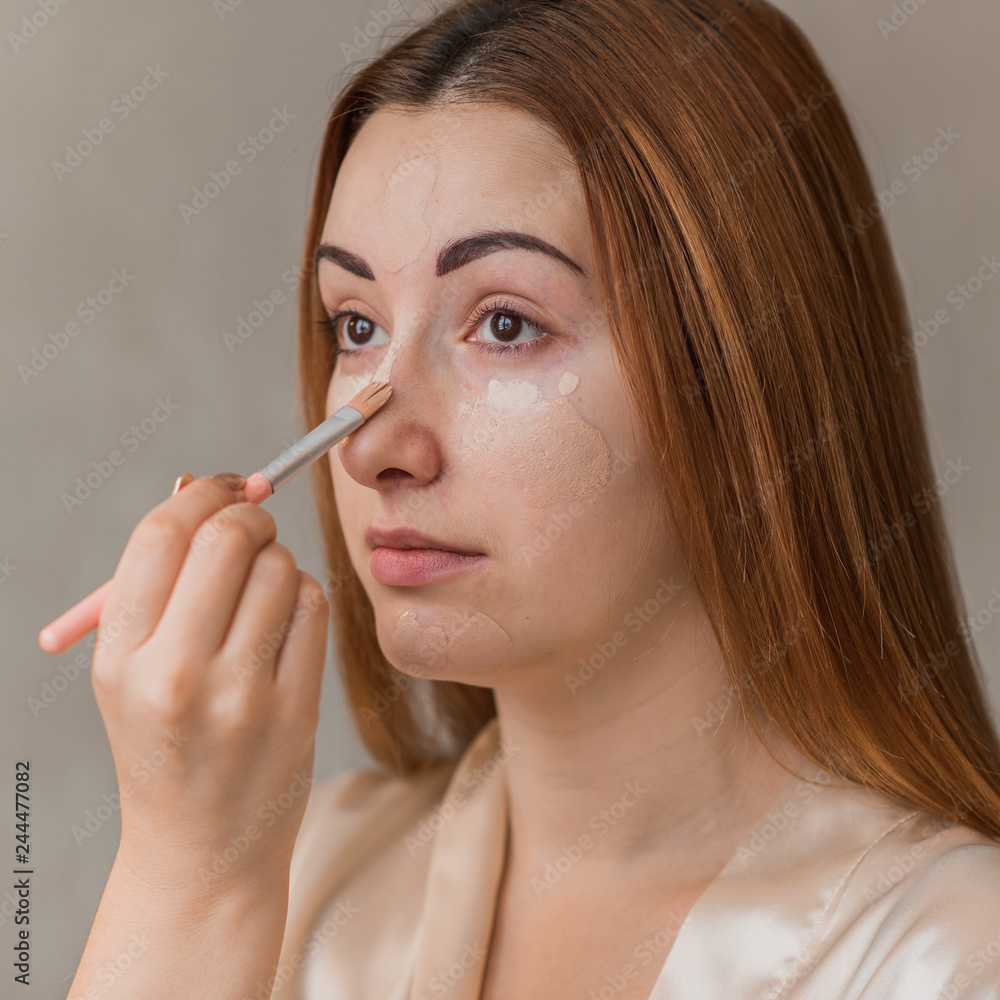 Woman applying foundation and concealer makeup. Do it yourself makeup for problem skin Woman applying foundation and concealer makeup. Do it yourself makeup for problem skin