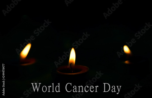 World Cancer Day concept: the candles burn brightly on the dark background