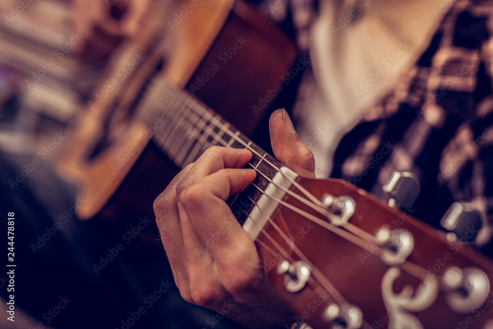 Fototapeta premium Close up of a male hand holding the guitar