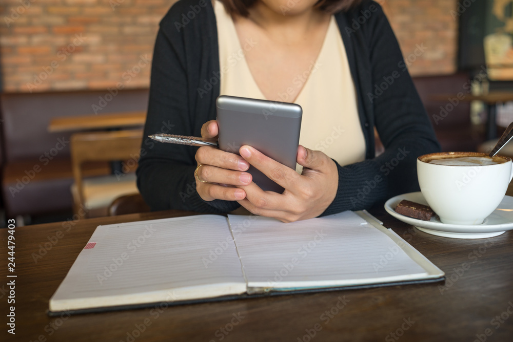 Young Asian lady using smartphone at the cafe Young Asian lady using smartphone at the cafe