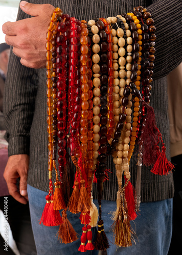 colorful amber rosaries, Merchants holding largest collection of rosaries for sale at street market