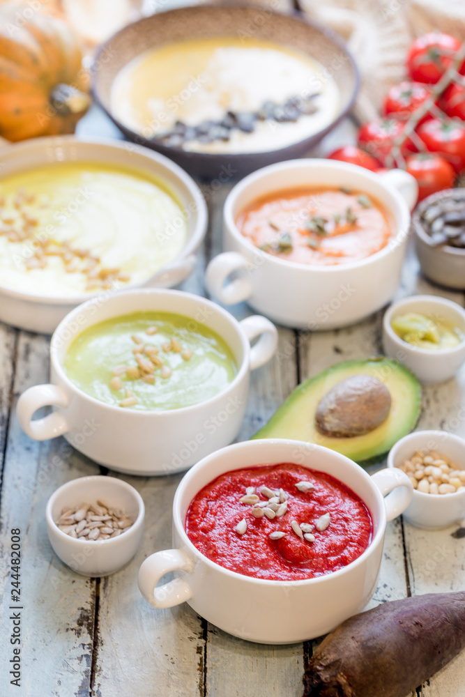 Variety of different colorful vegetable cream soups in a bowls. Concept of healthy eating or vegetarian food. Variety of different colorful vegetable cream soups in a bowls. Concept of healthy eating or vegetarian food.