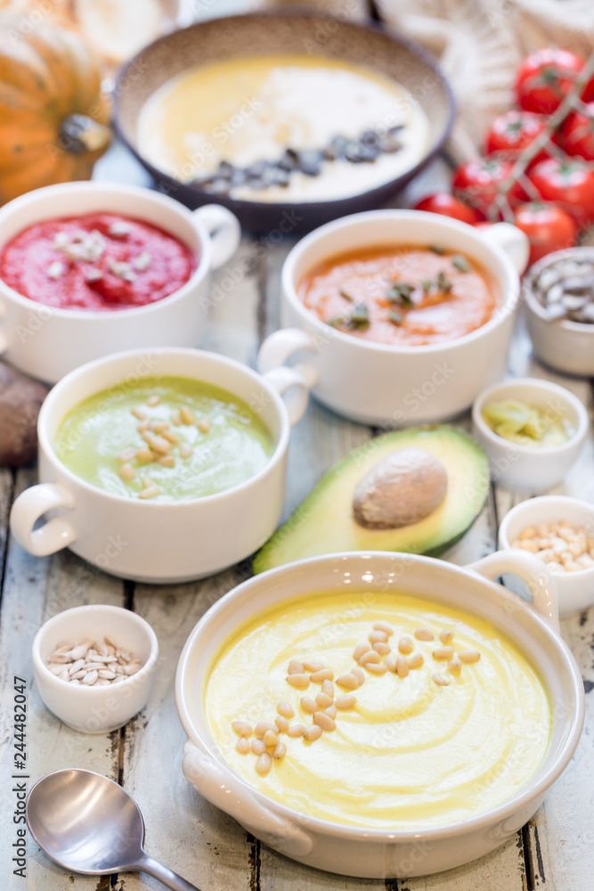 Variety of different colorful vegetable cream soups in a bowls. Concept of healthy eating or vegetarian food. Variety of different colorful vegetable cream soups in a bowls. Concept of healthy eating or vegetarian food.