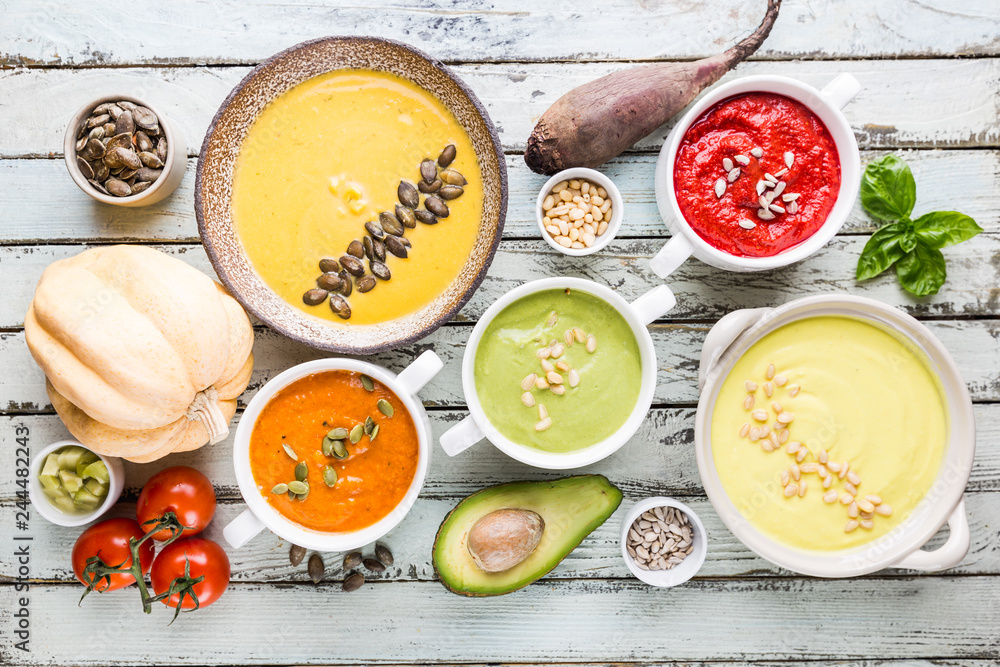 Variety of different colorful vegetable cream soups in a bowls, top view. Concept of healthy eating or vegetarian food. Variety of different colorful vegetable cream soups in a bowls, top view. Concept of healthy eating or vegetarian food.