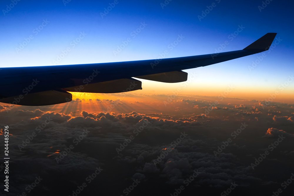 Beautiful view out of a airplane to a sunset, flying above clouds Beautiful view out of a airplane to a sunset, flying above clouds
