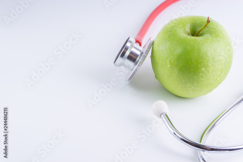 Green Apple with medical stethoscope isolated on white background for healthy eating. Selective focus and crop fragment. Healthy and copy space concept photo