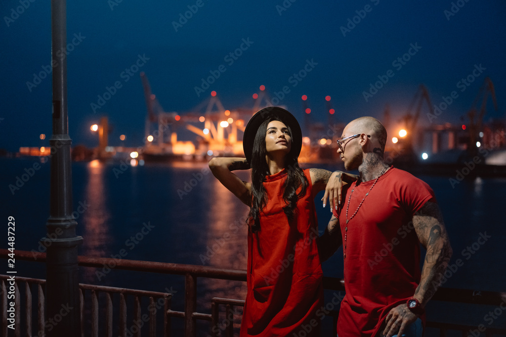 Young guy and beautiful girl on the background of the night port