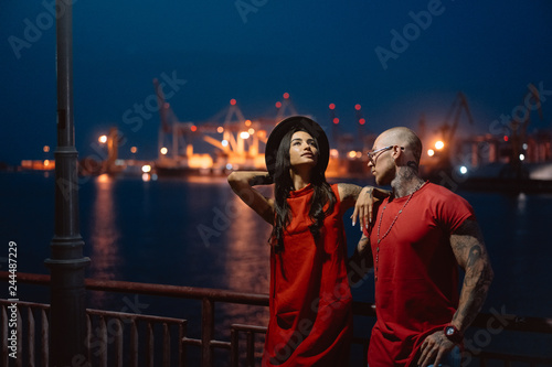 Young guy and beautiful girl on the background of the night port © teksomolika