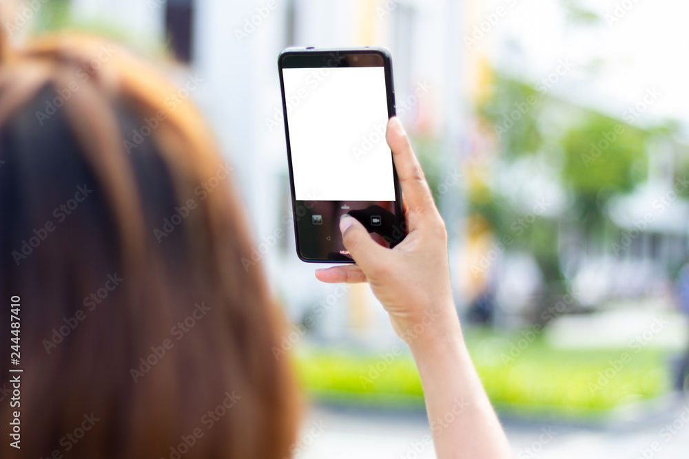 Mockup of a hand holding mobile phone with blank screen and making selfie or shooting someone at the party