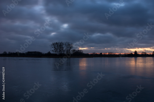 Cloudy sky after sunset, over a calm lake