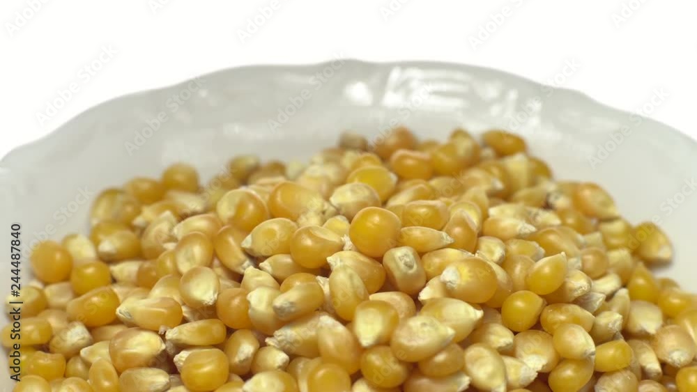 Corn grains in a bowl. Raw organic seeds of Zea mays. Sweet maize, cereal grains. Rotation. Close up. Studio shot. Isolated on white. Healthy food diet concept. Corn grains in a bowl. Raw organic seeds of Zea mays. Sweet maize, cereal grains. Rotation. Close up. Studio shot. Isolated on white. Healthy food diet concept.
