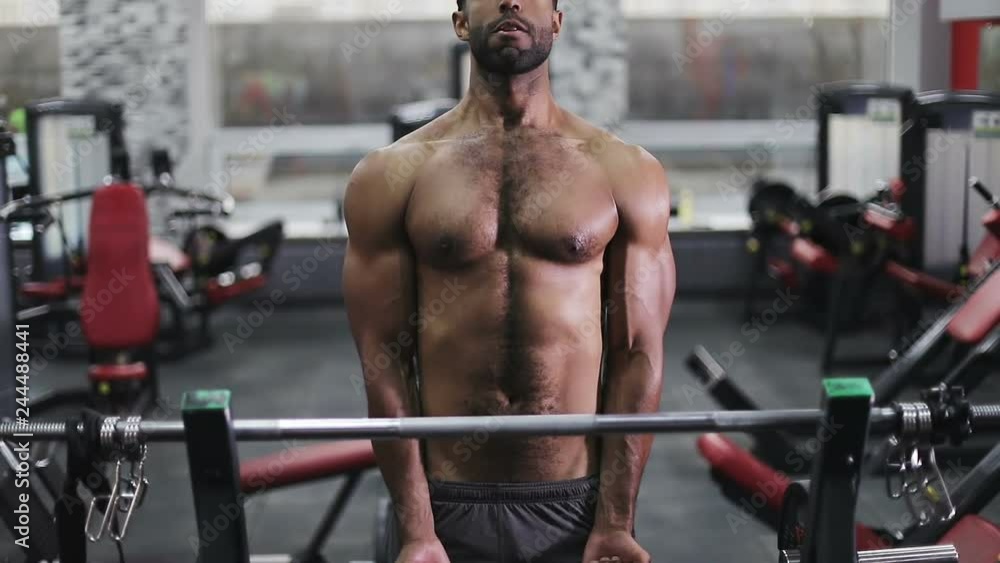Bodybuilder training biceps and chest with barbell in gym. Bodybuilder training biceps and chest with barbell in gym.