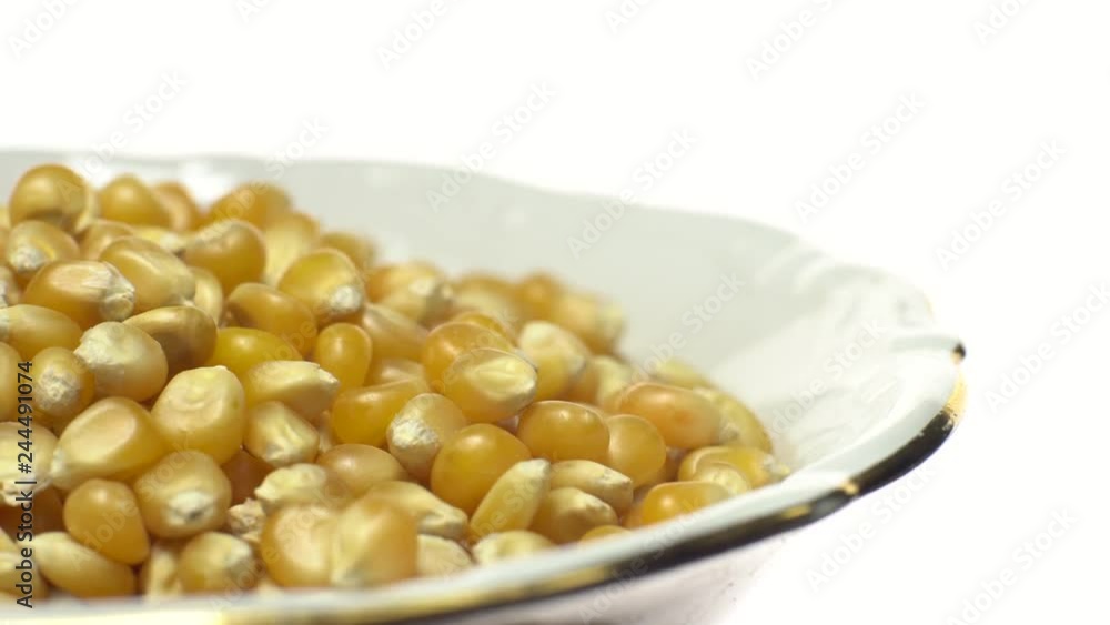 Corn grains in a bowl. Raw organic seeds of Zea mays. Sweet maize, cereal grains. Rotation. Close up. Studio shot. Isolated on white. Healthy food diet concept. Corn grains in a bowl. Raw organic seeds of Zea mays. Sweet maize, cereal grains. Rotation. Close up. Studio shot. Isolated on white. Healthy food diet concept.
