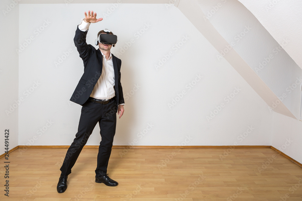 Fototapeta premium Mann nutzt die Vorteile der Digitalisierung. Er schaut sich seine virtuelle neue Wohnung an.