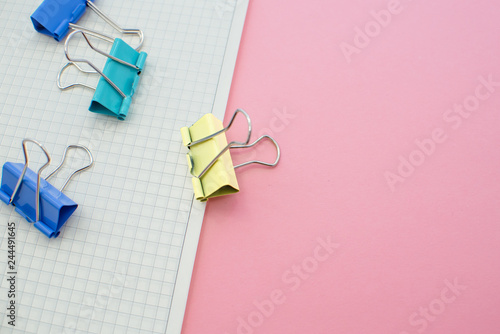 colored paper clips on a pink background. Office stationary © Elina