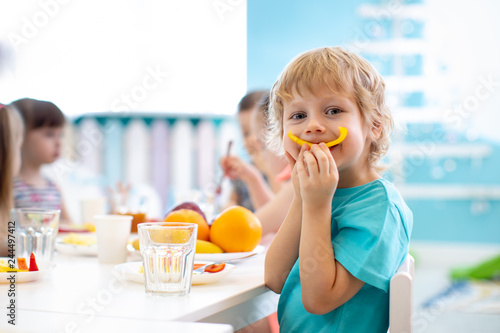 Funny kid boy eating fruits...