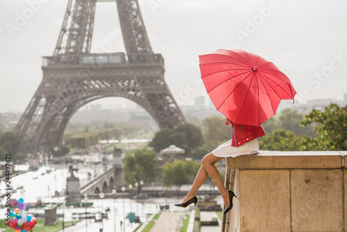 Girl hiding herself behind heart shaped red umbrella in front of the Eiffel tower © Anna