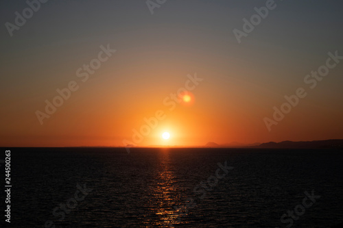 Beautiful morning sunrise over the sea showing yellow sun with a few clouds in the background, taken in Spain Costa Brava near Alicante and Benidorm 