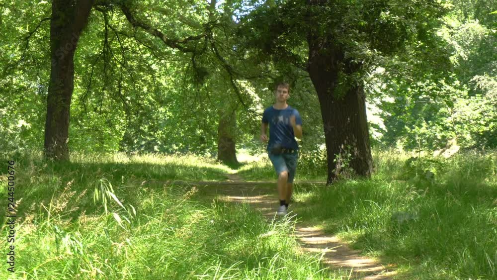 Youn Man Jogging on Nature Trail in Park Youn Man Jogging on Nature Trail in Park