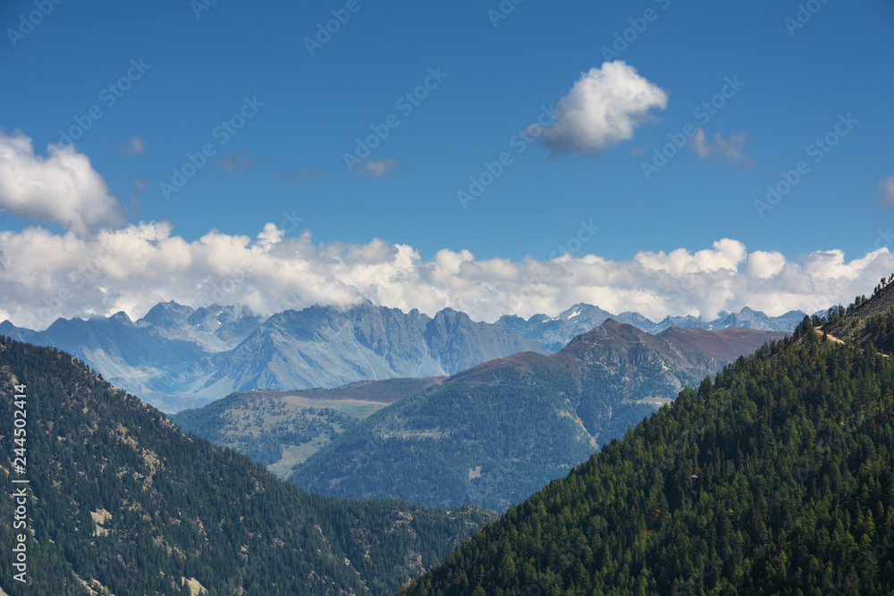 Landscapes of the Swiss alpine mountains against the background of a blue sky with small clouds.